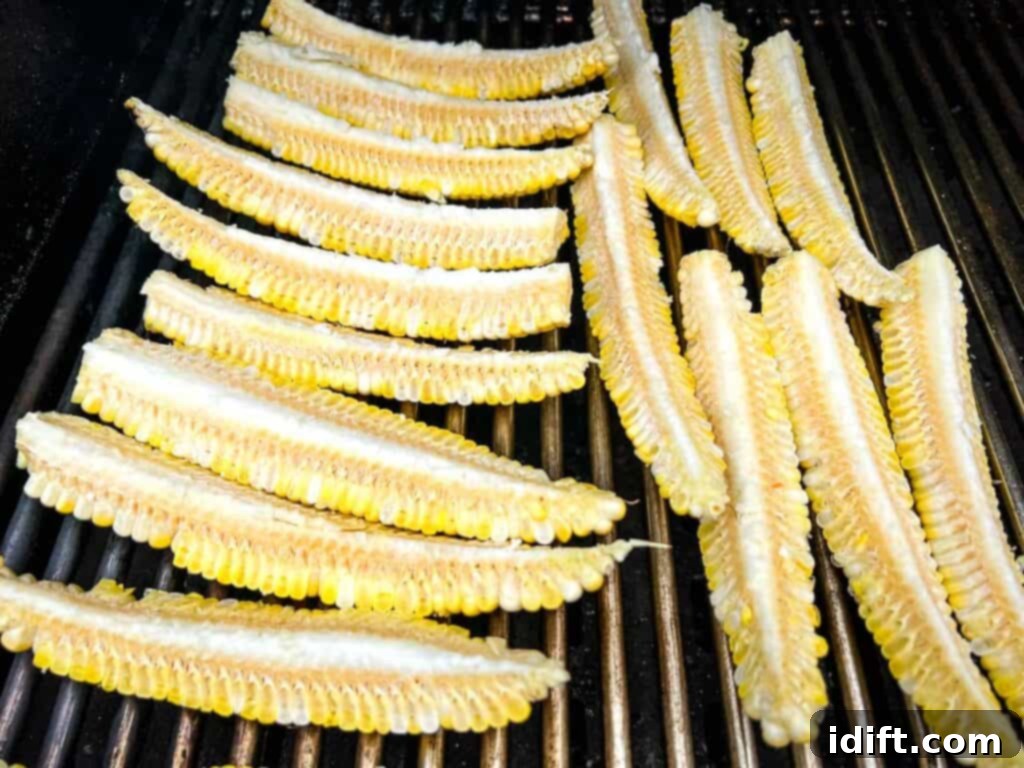 Corn ribs on a grill, showing the charring process and curling shape.