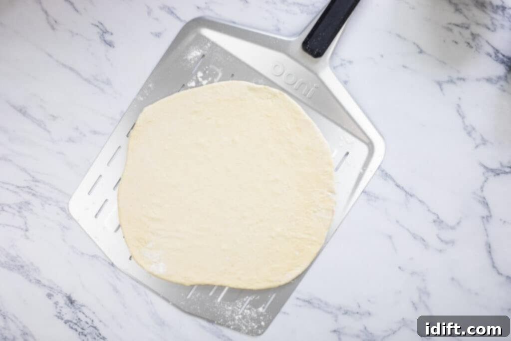 Asparagus and Prosciutto Masterpiece 8 Rolled pizza dough on a cornmeal-dusted pizza paddle.