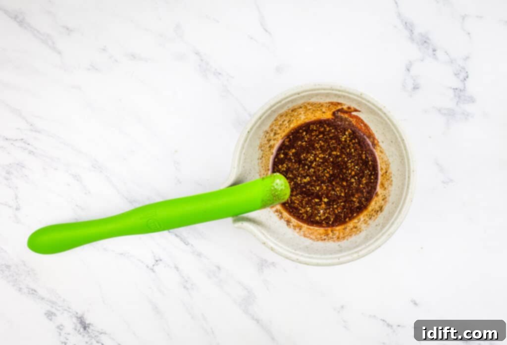 Tender Hanger Steak with Bright Chimichurri 8 Spices and olive oil being mixed together in a small bowl.