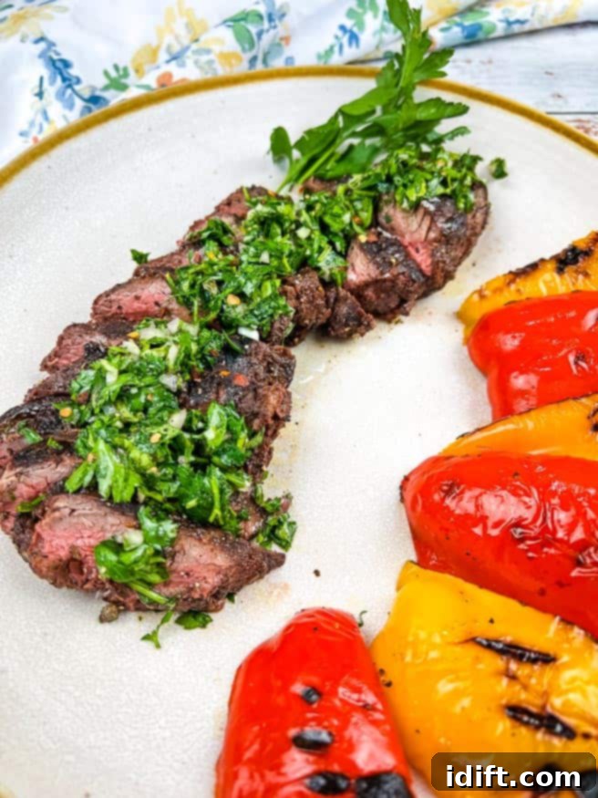 Tender Hanger Steak with Bright Chimichurri 13 Finished grilled hanger steaks sliced and topped with chimichurri, served with grilled peppers.