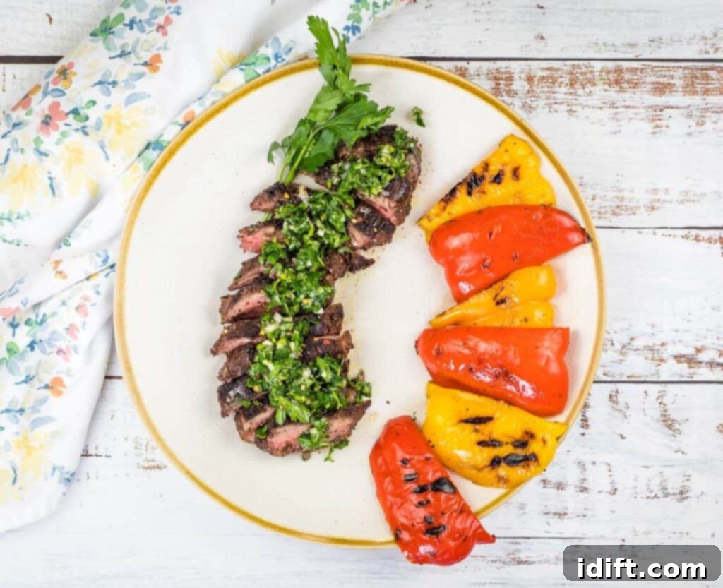 Tender Hanger Steak with Bright Chimichurri 6 Finished grilled hanger steaks with chimichurri and grilled peppers on a serving platter.