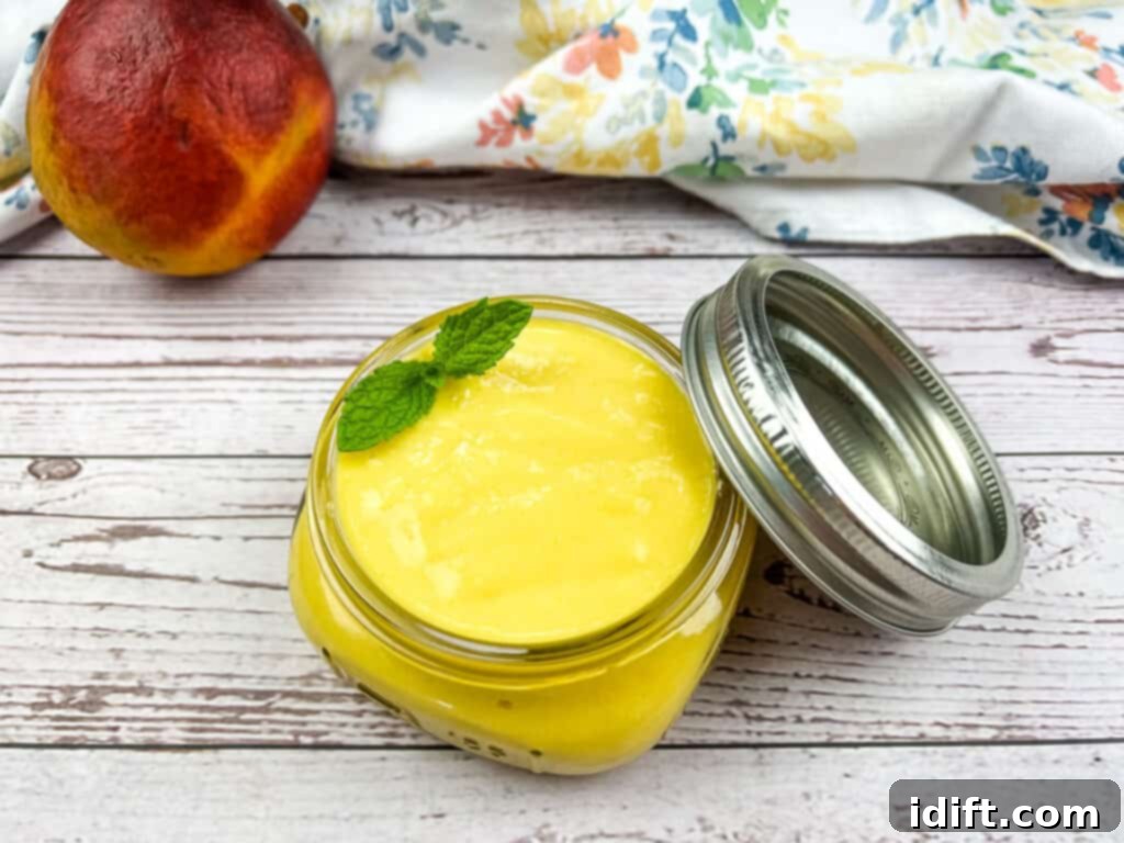 A sealed glass jar filled with luscious mango curd, showcasing its vibrant color and smooth texture.