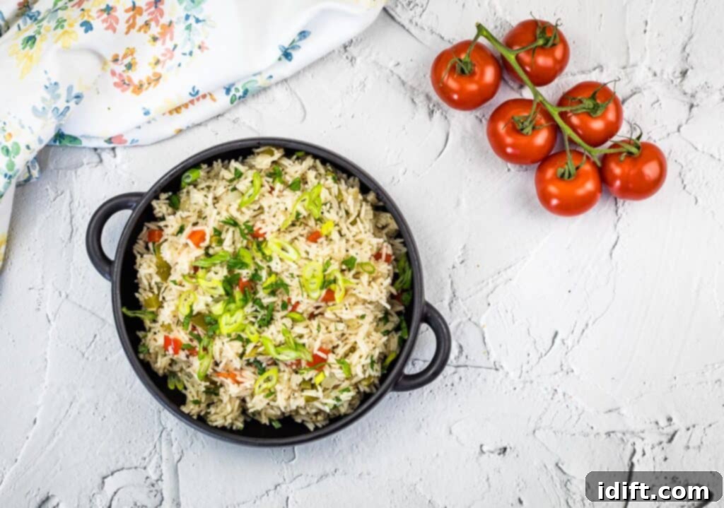 Vibrant Mediterranean Rice 3 A top-down shot of Mediterranean Rice in a bowl on a counter with fresh tomatoes and herbs.