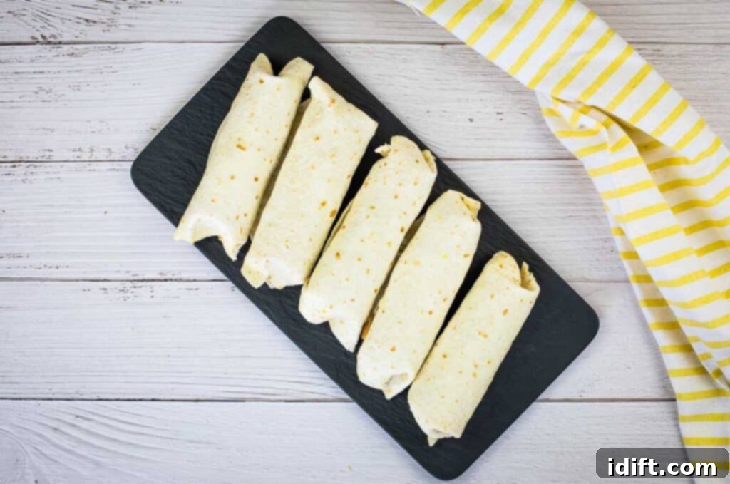 A top-down shot of Freezer Breakfast Burritos on a black platter.