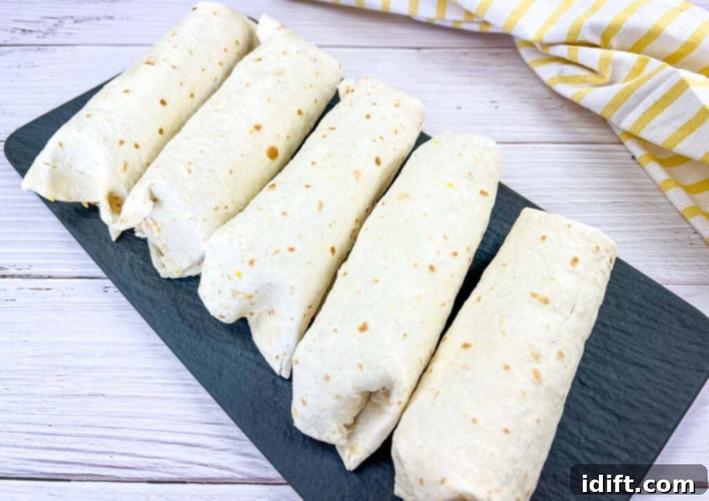 Breakfast burritos on a black platter.