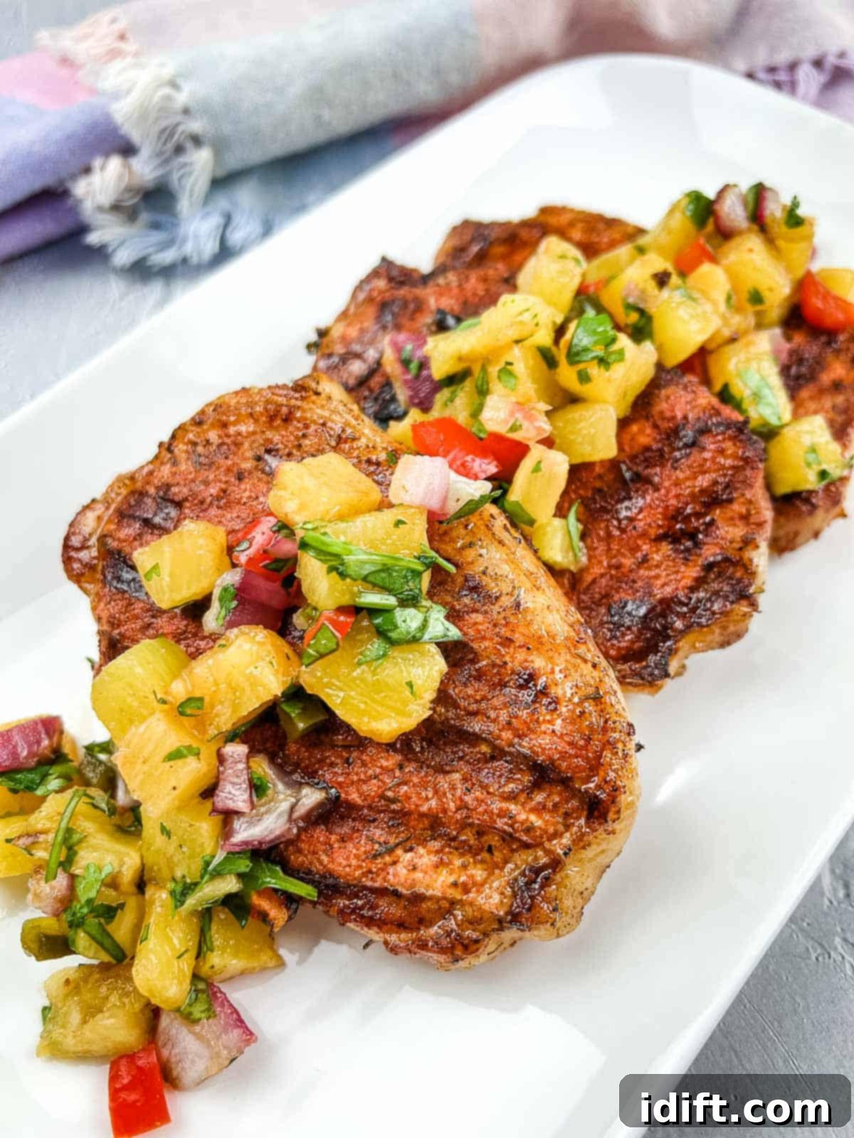 Ninja Woodfire Grill Pork Chops with Pineapple Salsa on a white plate.