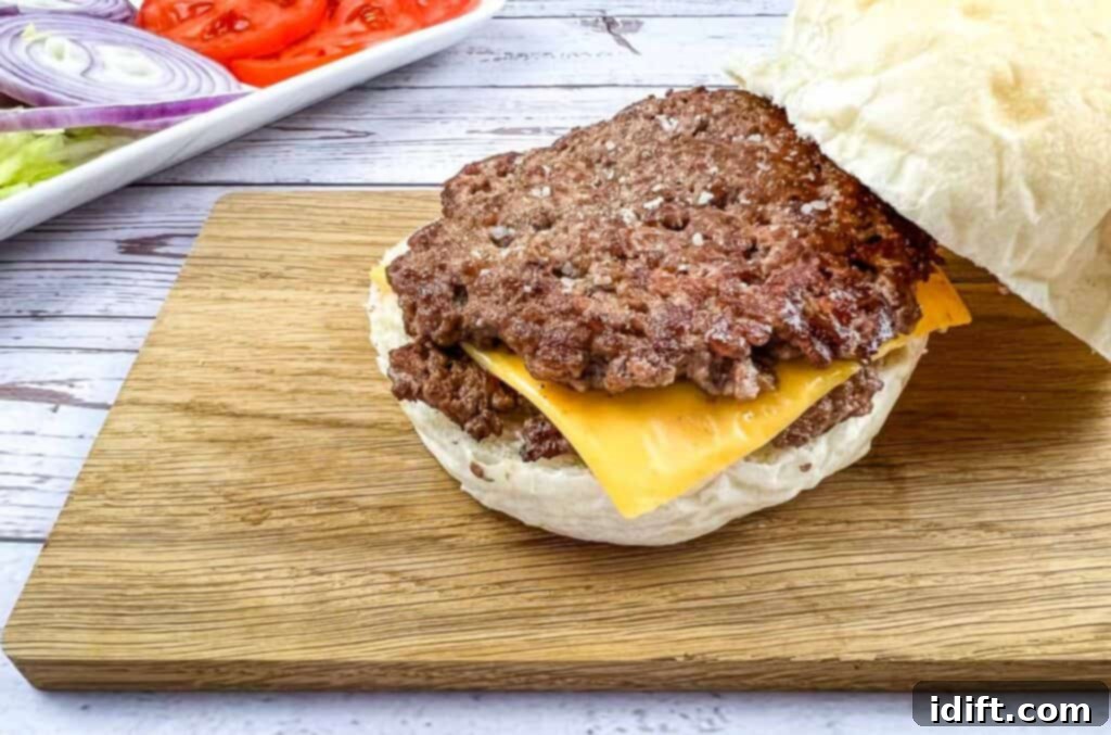 Griddle Gold: The Art of the Blackstone Smash Burger 3 A perfectly cooked Blackstone Griddle Smash Burger resting on a wooden cutting board.