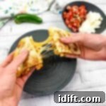 Two hands pulling apart a Chicken Al Pastor Quesadilla.