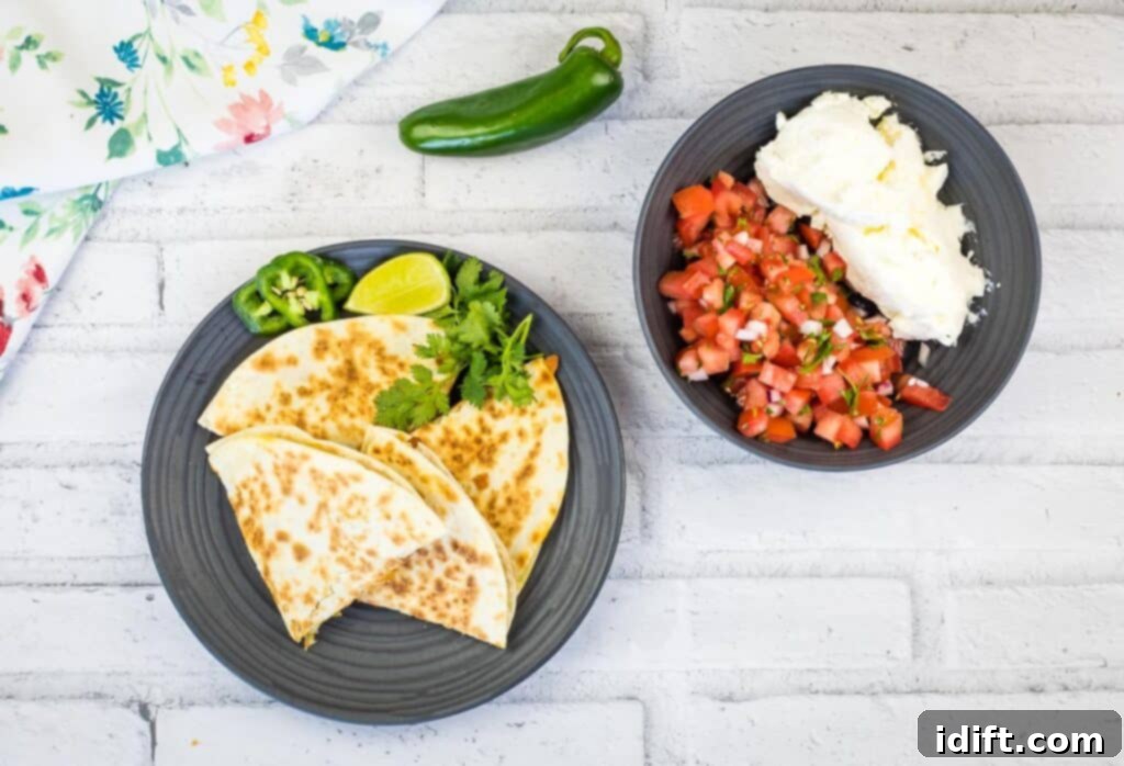A top-down shot of Chicken Al Pastor Quesadillas cut in wedges, garnished with fresh cilantro and served with a side of vibrant salsa.