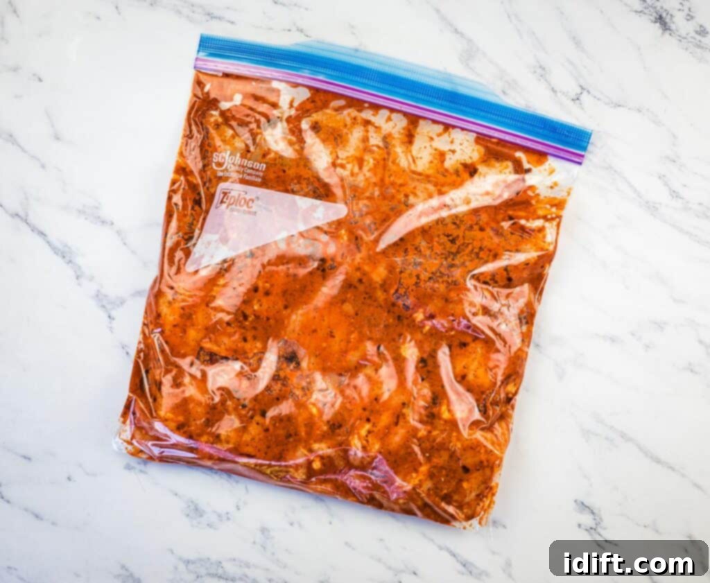 Chicken thighs marinating in a plastic bag with the rich al pastor sauce.