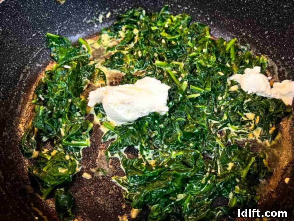 Velvet Mascarpone Spinach Your Ultimate Creamy Side 9 Mascarpone cheese being added to the creamy spinach mixture.