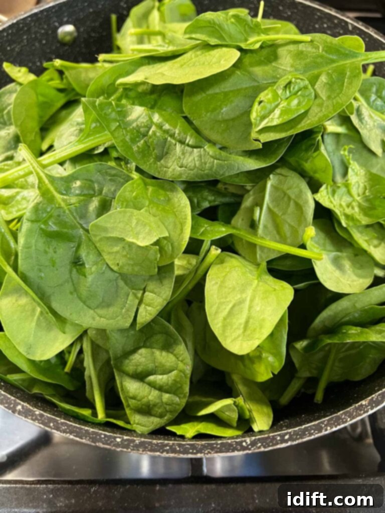 Velvet Mascarpone Spinach Your Ultimate Creamy Side 5 Fresh baby spinach in a skillet, ready to be cooked.