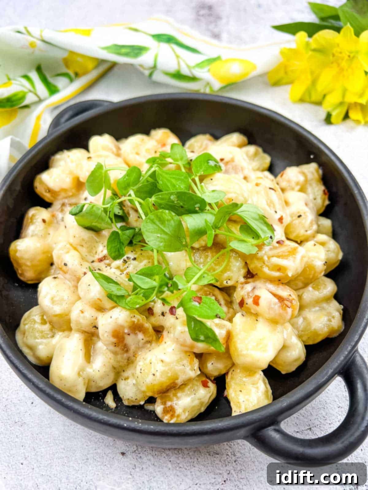 Gnocchi with Lemon Parmesan Sauce in a black serving dish, garnished with fresh parsley.