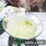 Smoked Gimlet in a glass with smoke coming off the top of it.