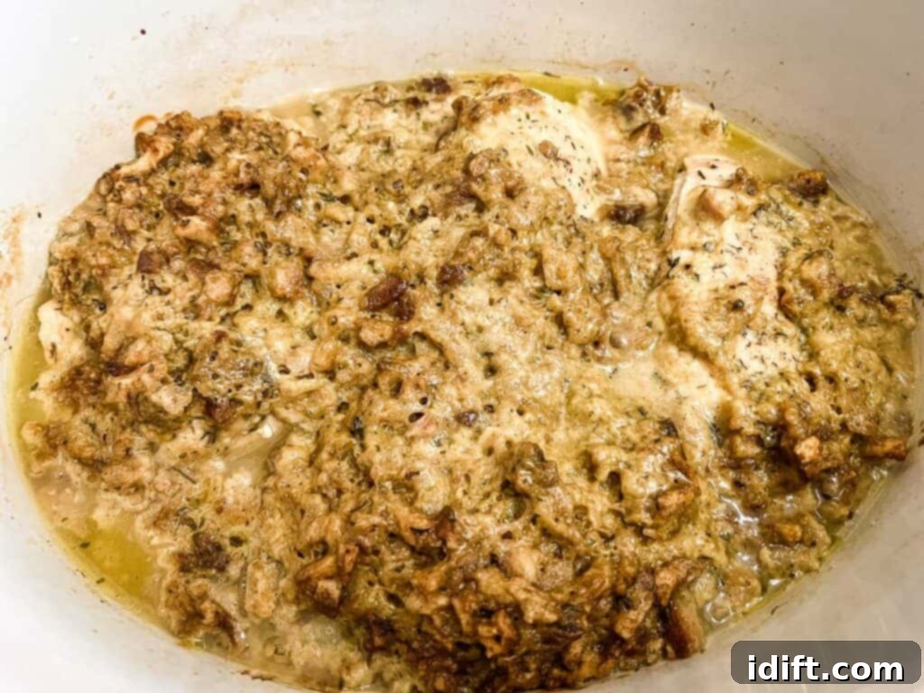 Cooked 4-ingredient slow cooker chicken in the slow cooker, glistening and ready.