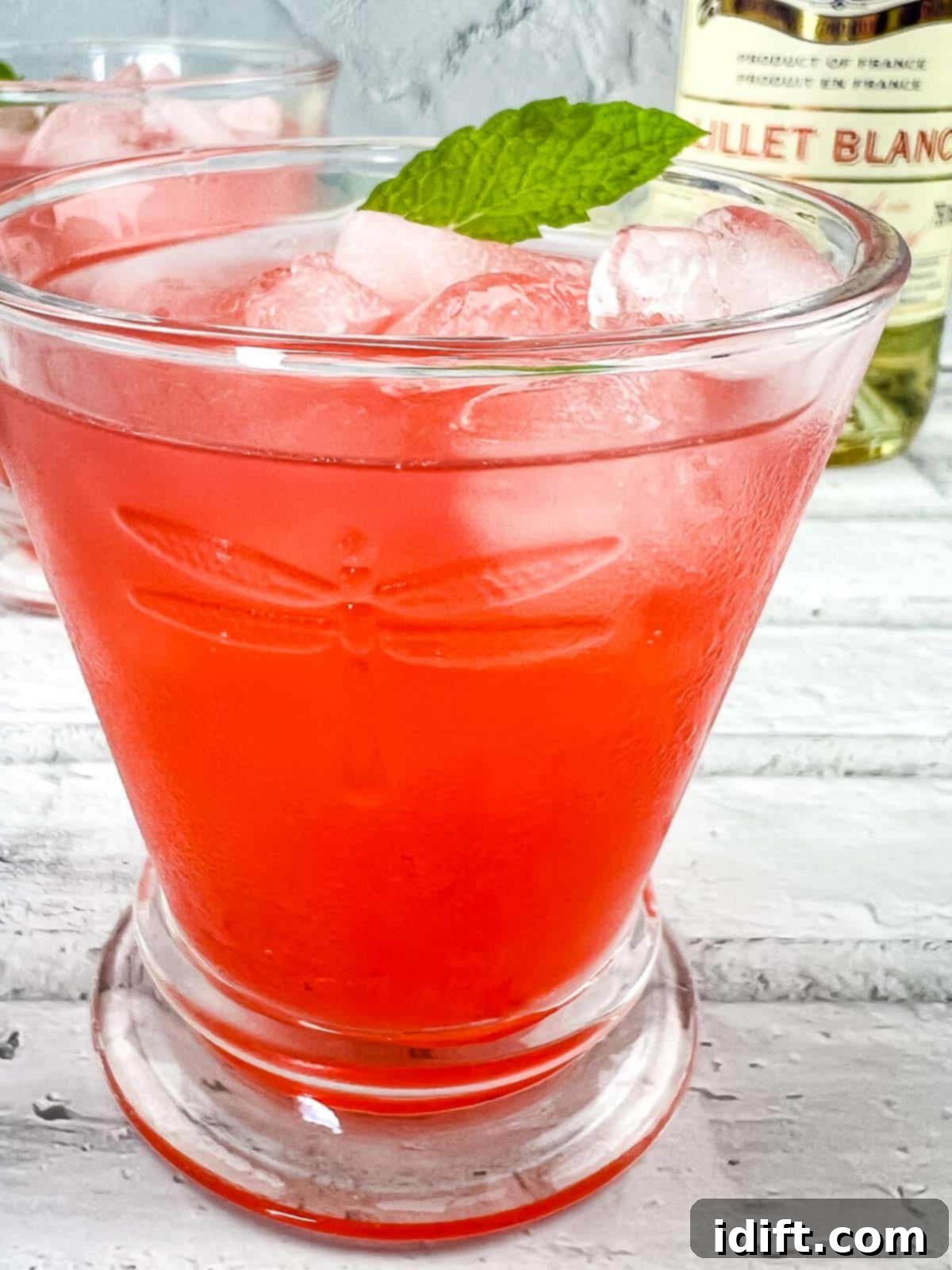 A refreshing Strawberry-Lillet Crush cocktail in a glass, garnished with fresh mint.