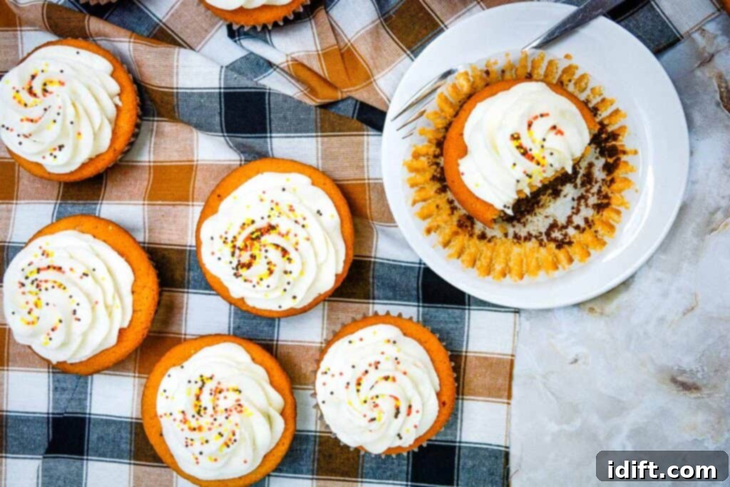Autumn Fudgy Brownie Bites 3 Close-up shot of perfectly iced Fall Brownie Cupcakes, featuring the distinct two-tone layers and festive sprinkles, arranged on a textured cloth.