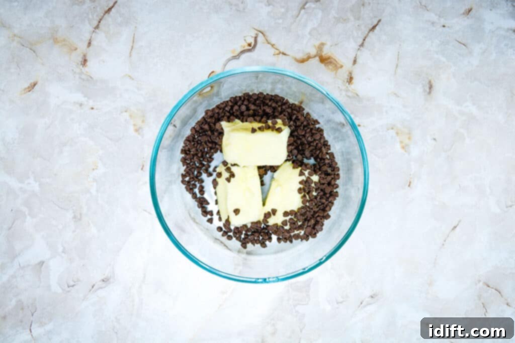 Autumn Fudgy Brownie Bites 6 Butter and chocolate chips melting together in a microwave-safe bowl, forming a smooth, glossy mixture for the brownie base.