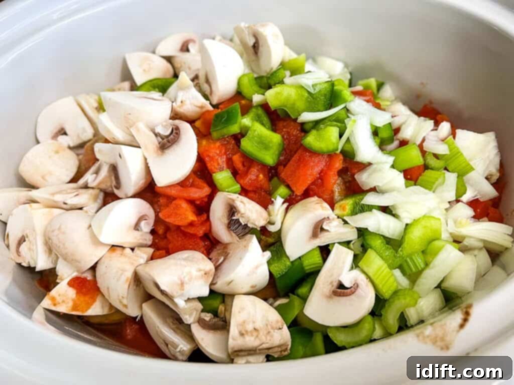 Browned pork chops resting in a slow cooker with all other ingredients added.