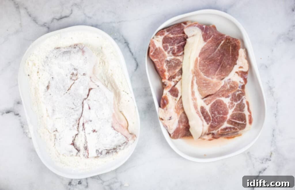 Seasoned flour in a bowl with a dredged pork chop, ready for cooking.