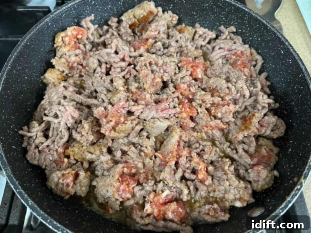 Priceless Pasta Bake 10 A frying pan filled with ground beef.