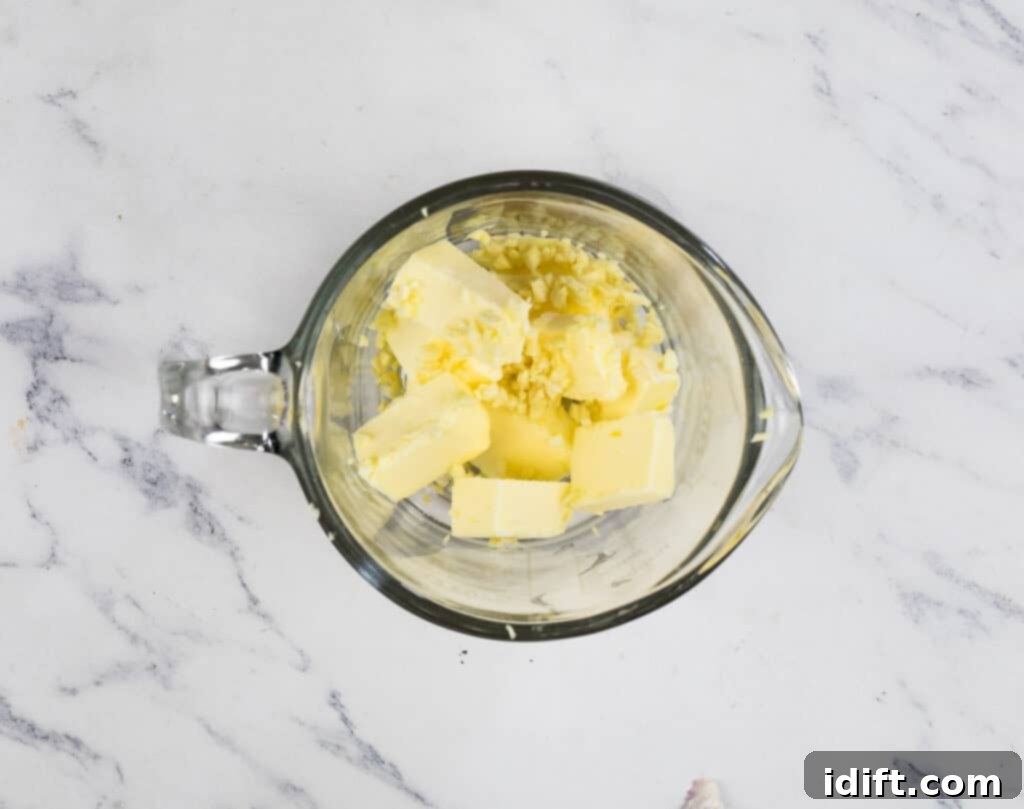 Irresistible Smoked Garlic Parmesan Wings 8 Butter and garlic in a bowl on a marble table.