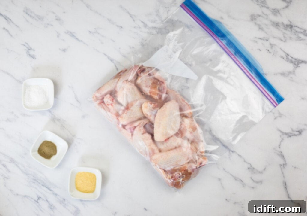 Irresistible Smoked Garlic Parmesan Wings 7 Chicken wings in a plastic bag on a marble countertop.