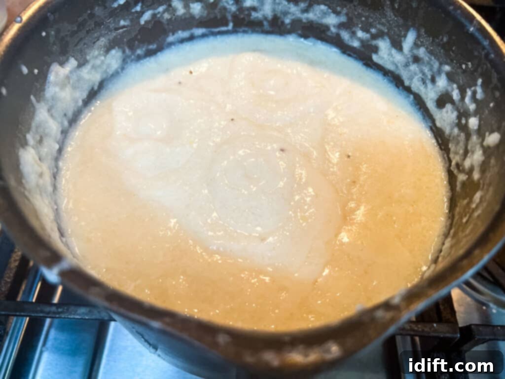 Comforting Baked Shrimp and Grits Casserole 11 A pot on the stove, where grits are simmering and thickening.
