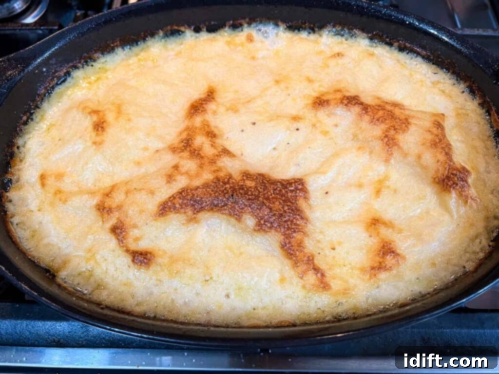 Comforting Baked Shrimp and Grits Casserole 13 A casserole dish filled with baked, cheesy grits, golden and ready for the topping.