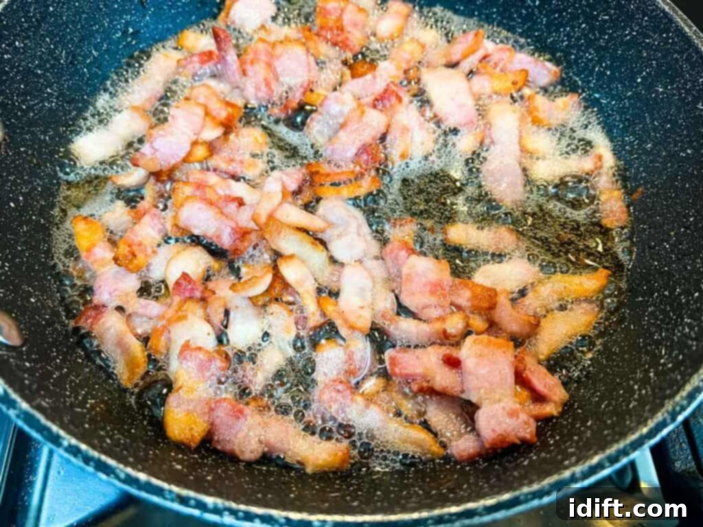 Comforting Baked Shrimp and Grits Casserole 15 Bacon cooking in a large frying pan until crispy.