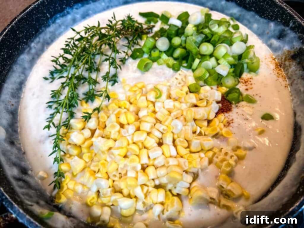 Comforting Baked Shrimp and Grits Casserole 18 Corn niblets and other vegetables being added to a creamy sauce in a skillet.