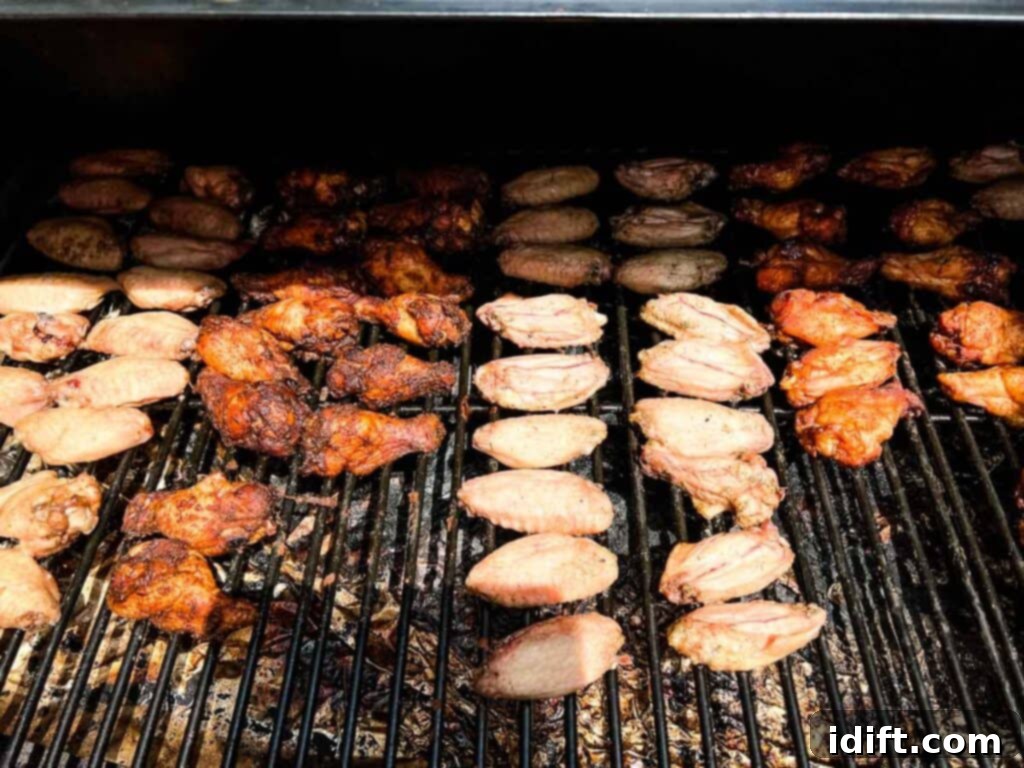 Chicken wings smoking on a pellet grill, infused with wood-fired flavor.