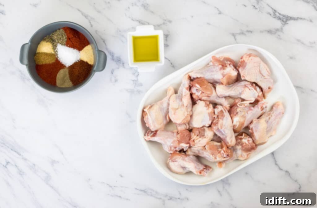 Chicken wings in a bowl with spices and seasonings ready to be mixed.