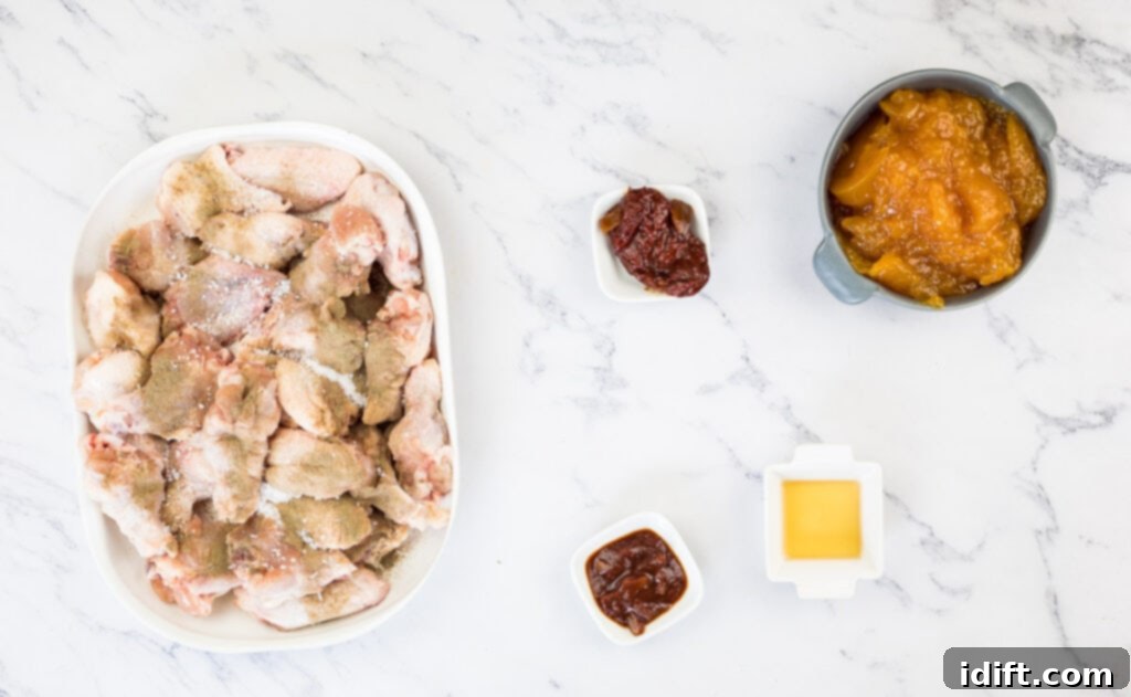 A plate of chicken wings and sauce on a marble table.