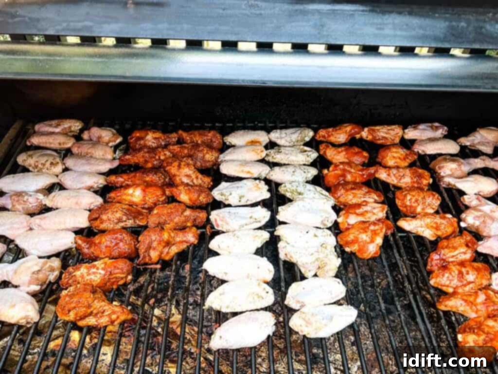 Chicken wings arranged on a grill grate inside a smoker.