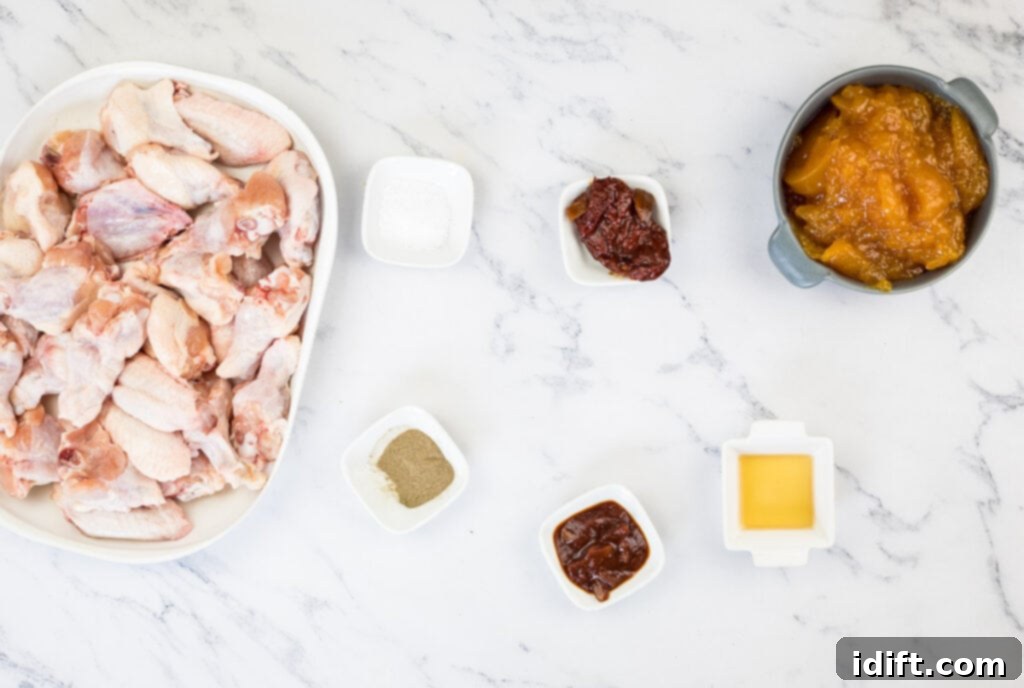 The organized ingredients for Smoked Peach-Chipotle Wings laid out on a marble table.