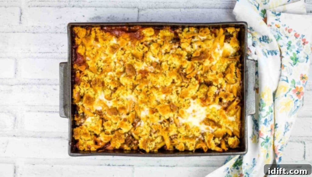 Hearty Sloppy Joe Noodles 3 A large baking dish filled with a golden-brown Sloppy Joe pasta casserole, fresh out of the oven, with steam gently rising from the surface.