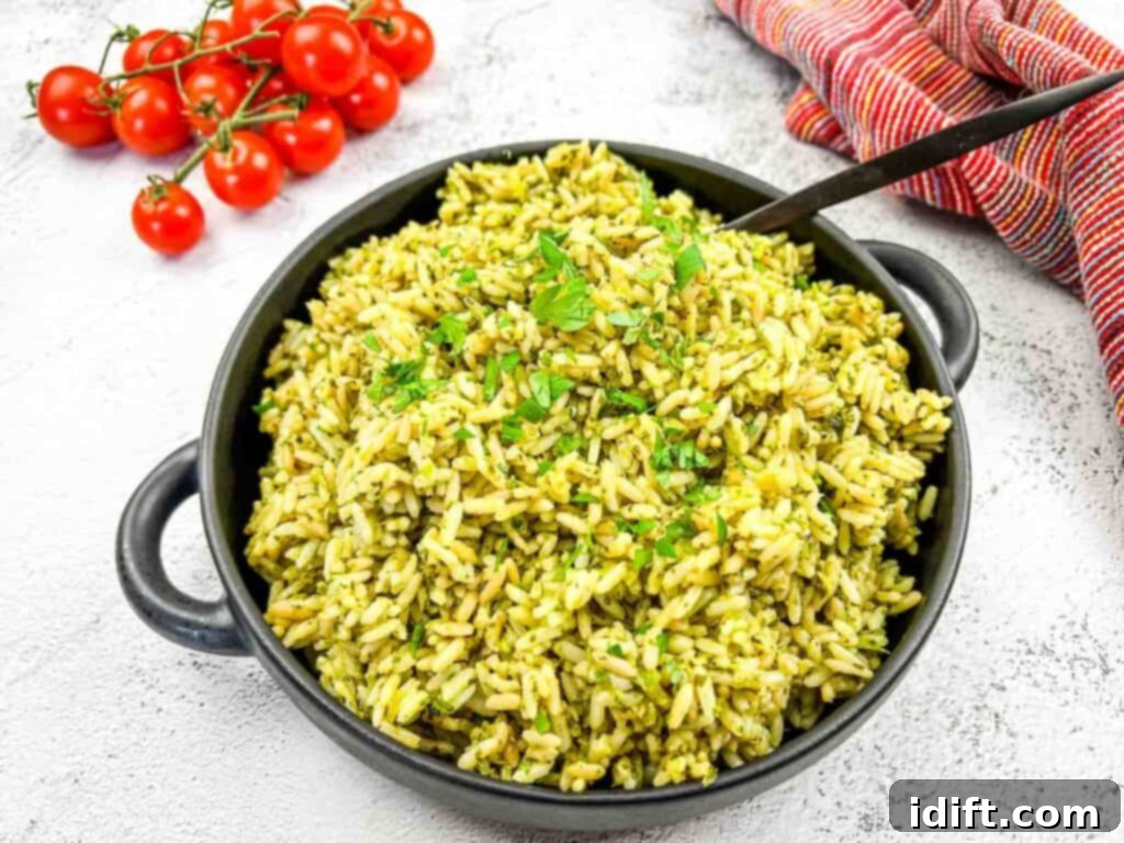 Emerald Herb Rice 2 A bowl of vibrant green rice, garnished with fresh tomatoes and parsley, ready to be served.