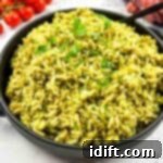 Emerald Herb Rice 9 Green rice in a skillet with tomatoes and herbs.