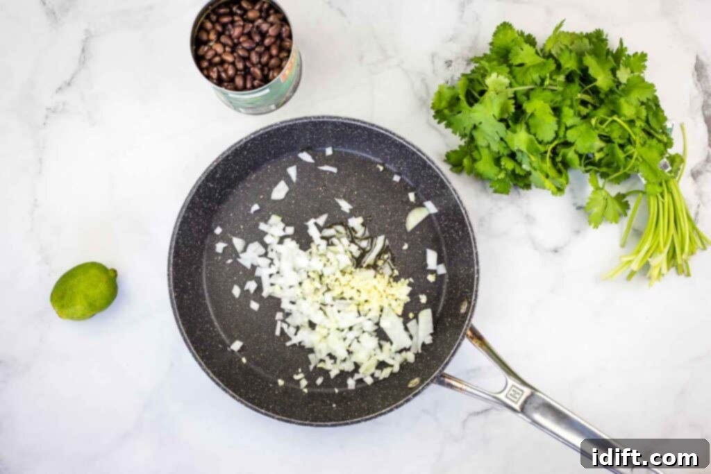 Ingredients in a frying pan on a marble countertop.