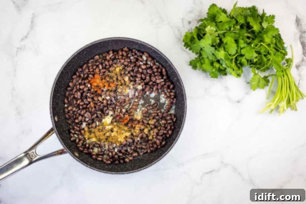 Black beans in a frying pan with parsley.