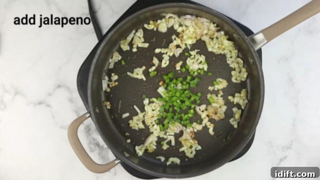 A pan with onions and diced jalapenos cooking.