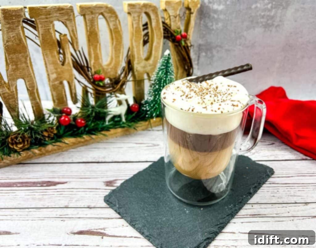A charming close-up of Canadian Coffee in a clear glass mug, topped with whipped cream and a sprinkle of chocolate. The background features blurred festive decorations, suggesting a cozy, holiday atmosphere.
