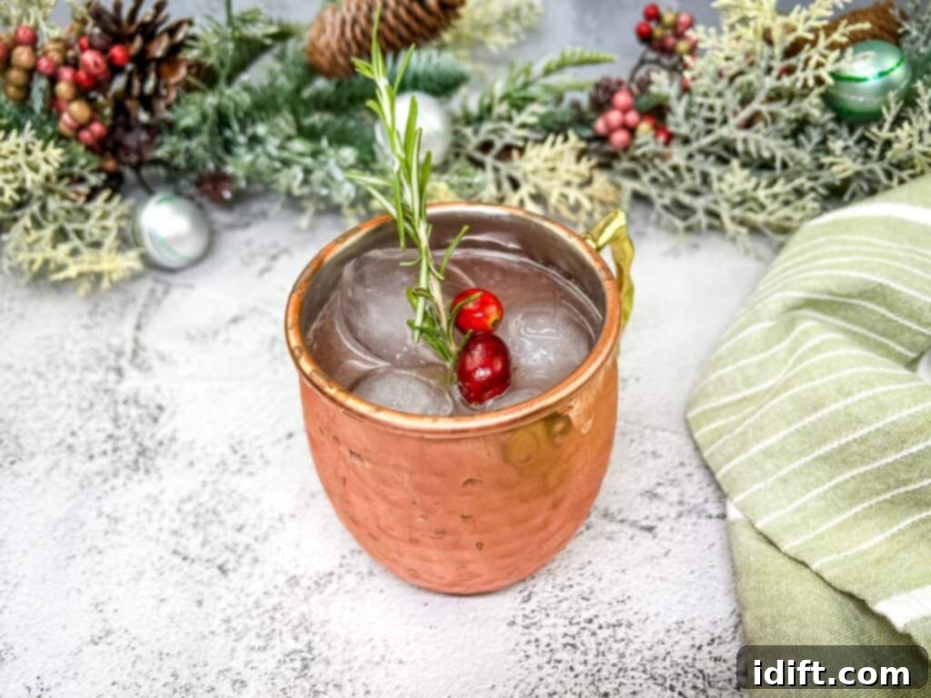 A mistletoe mule with cranberries and a sprig of rosemary.