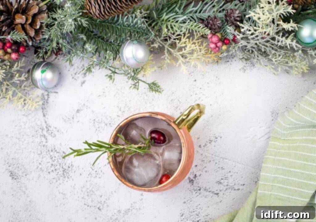 A copper mug surrounded by christmas decorations.