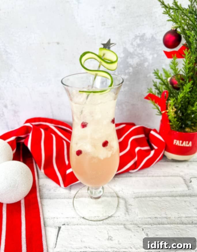 White Christmas Cocktail beautifully garnished, with a festive Christmas tree in the background, perfect for holiday celebrations.