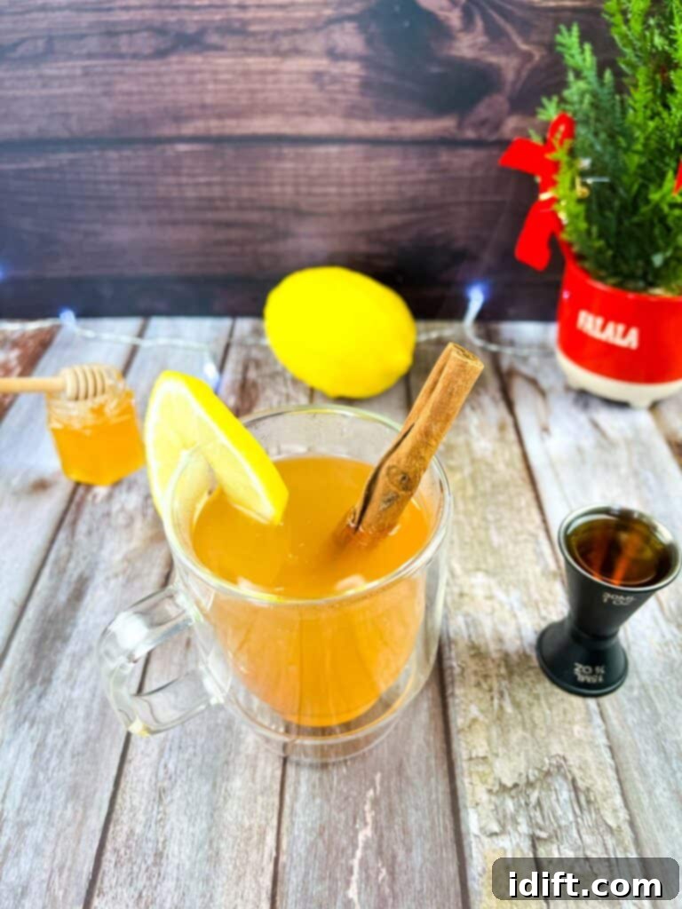Soothing Lemon Ginger Toddy Blend 2 A cup of tea with lemon and cinnamon on a wooden table.