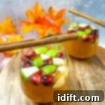 Two glasses of cranberry cranberry sangria with cinnamon sticks.