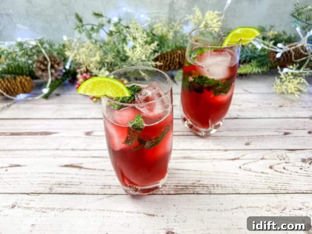 Two glasses of Pomegranate Mojitos on a rustic wooden table, ready to be served.