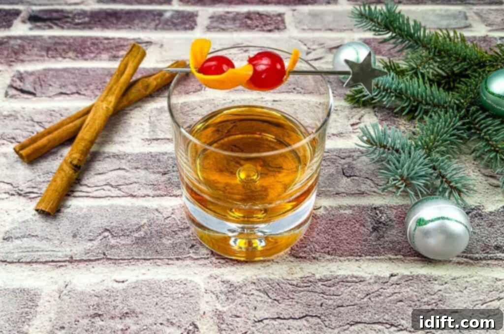 A glass of whiskey with cinnamon sticks and holiday ornaments on a brick wall, showcasing the festive theme.